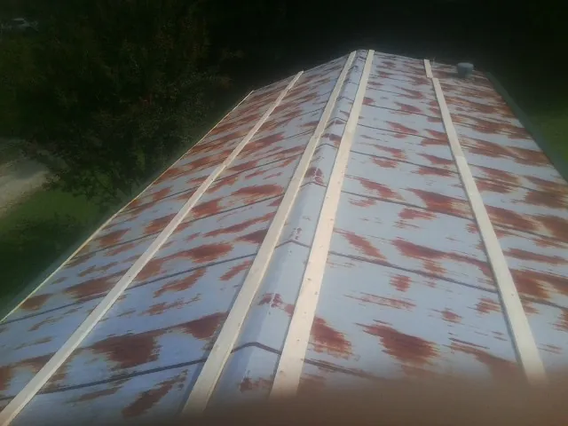Rusted metal roof panels with new wood purlins before replacement — Storm Damage Roof Repair in Bryan by Roofing Brothers